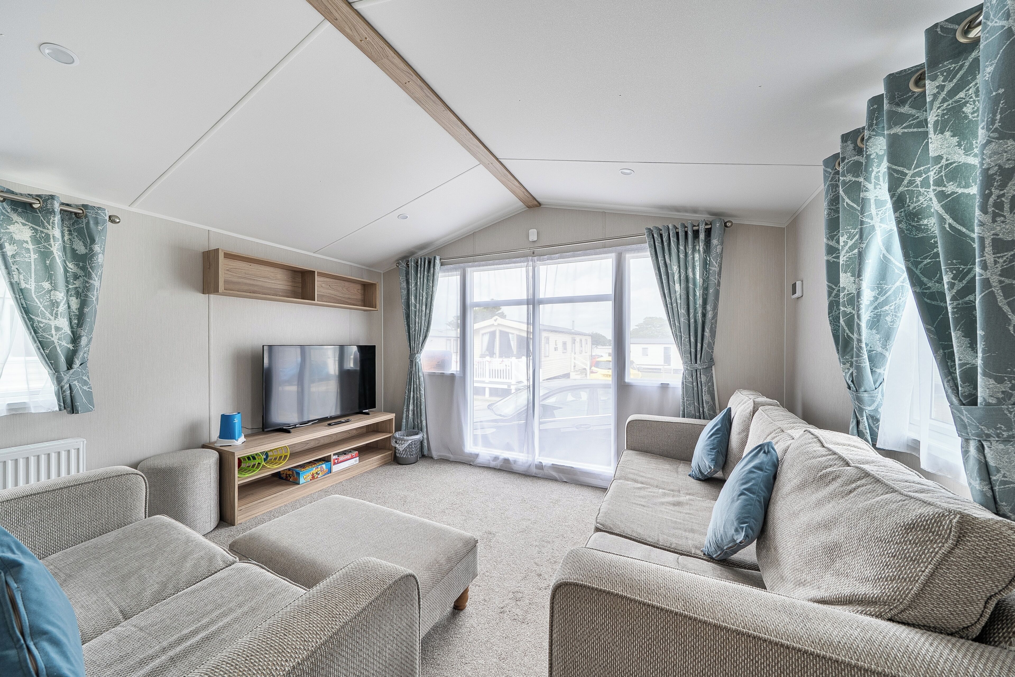 A living room with a television, wooden shelves, and a sofa.