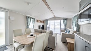 Ein modernes Wohnmobil-Interieur mit Essbereich, Sitzgelegenheiten und einer Küchenzeile.