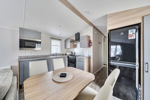 Una cocina compacta con microondas, estufa y refrigerador.