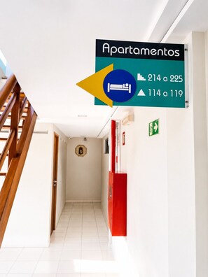 Un couloir avec une signalétique indiquant les numéros d’appartement allant de 214 à 225 et de 114 à 119.