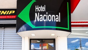 A hotel entrance with a staircase leading to the lobby, a sign for Hotel Nacional, and a visible store with products.