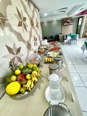 A buffet with various fruits and a water dispenser. - Hotel Nacional (ARAPIRACA)