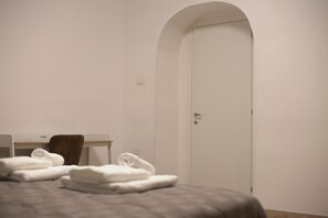 A hotel room with a bed, a desk, and a door. - Naples Holiday House with Private Terrace, near Station, Metro, Airport (Napoli)