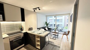 A modern kitchen with a dining area, a small island, and a view of the outside. - Modern, centrally located apartment steps from the Movistar Arena (Santiago)
