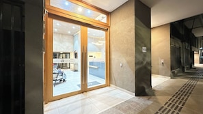 Ein Hotel mit Eingang, Glastür, einer Rezeption und einem gefliesten Boden.