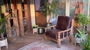 A cozy room with a wooden chair, a large window, and a plant. - Quiet vacation home "Zum Holzwurm" with large terrace & winter garden! (Molbergen)