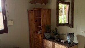 A bedroom with a bed, wooden wardrobe, and a window with a view. - Quiet vacation home "Zum Holzwurm" with large terrace & winter garden! (Molbergen)
