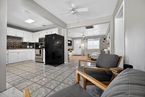Un amplio espacio habitable con cocina, mesa de comedor y zona de estar con sillas.