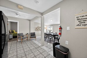 Un salon moderne comprenant un coin repas, une cuisine et un couloir.