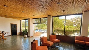 A spacious room with a bamboo ceiling, large windows, and orange seating. - Modern 2 Bedroom apartment in Juangriego with Pool (Juangriego)