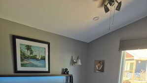 A neatly made bed with a basket of glasses and a bottle, a framed painting on the wall, and a window with a view of the outside. - Northern Paradise on the lake with water activities, Pet-friendly (Hagar)