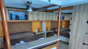 A compact room with a bunk bed, a small desk, and a ceiling fan. - Seaside Ntounas Apartments - Ammoudara Triple Gem (Agios Nikolaos)