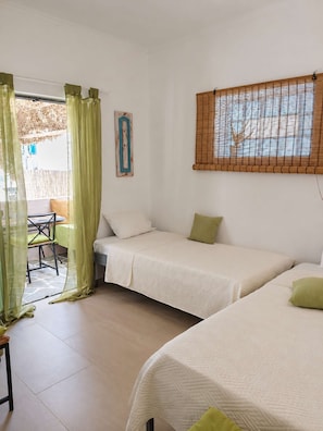A room with two single beds, a small table, and a chair. - Votsalon Beach House - Family Retreat Zakynthos (Zakynthos)