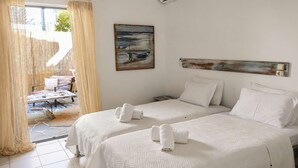 A hotel room with two beds, a painting, an air conditioner, and a view of the outdoors. - Votsalon Beach House - Gem for 2 in Zakynthos (Zakynthos)