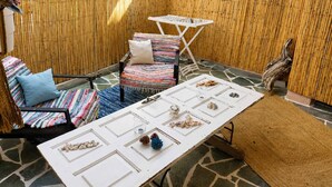 A patio with a table, chairs, and a bamboo wall. - Votsalon Beach House - Gem for 2 in Zakynthos (Zakynthos)