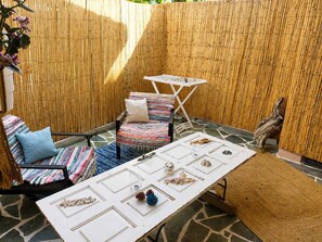 Eine Terrasse mit Tisch, Stühlen und einer Bambuswand.