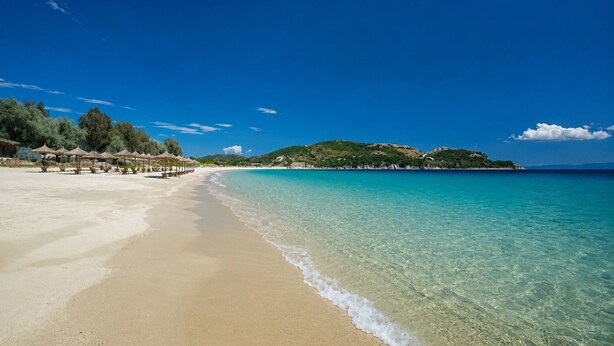 A beach with clear water, a sandy shore, and a small hill in the background. - Votsalon Beach House - Gem for 2 in Zakynthos (Zakynthos)