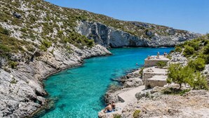A coastal area with clear turquoise waters, rocky terrain, and a small stone structure with people relaxing. - Votsalon Beach House - Gem for 2 in Zakynthos (Zakynthos)