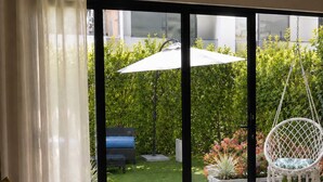 Ein modernes Wohnzimmer mit einem großen Schiebeglastür, die zu einer Terrasse im Freien führt.