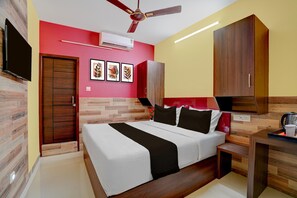 A bedroom with a bed, a ceiling fan, a TV, and a wardrobe.