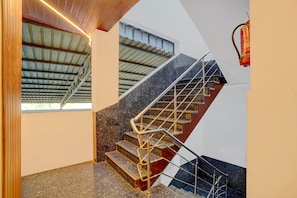 A modern staircase with metal railings, granite steps, and a wooden ceiling. - Super Collection O Kovur (Chennai)