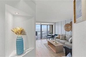 A modern living room with a sofa, coffee table, and a decorative vase. - 1BR Beach Cove - Oceanfront - Multiple Pools - Premier Location in North Myrtle (North Myrtle Beach)