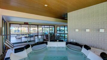Un área de spa con hidromasaje, asientos y vistas al exterior.