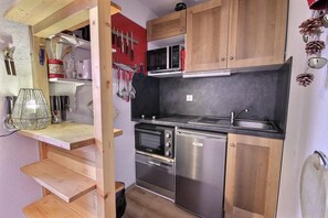 Eine kleine Küche mit Mikrowelle, Backofen und Geschirrspüler.