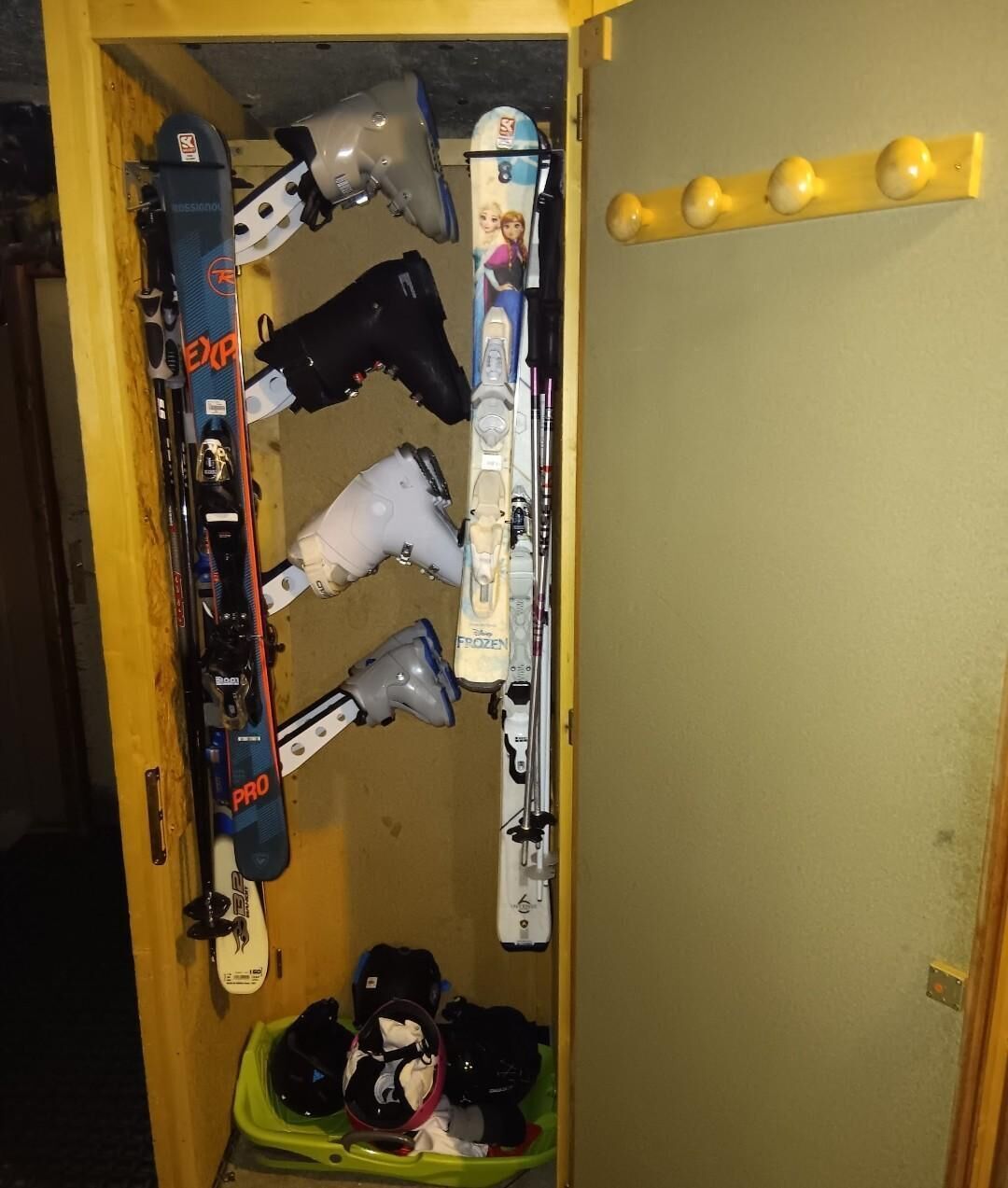 A ski storage area with skis, boots, and helmets.
