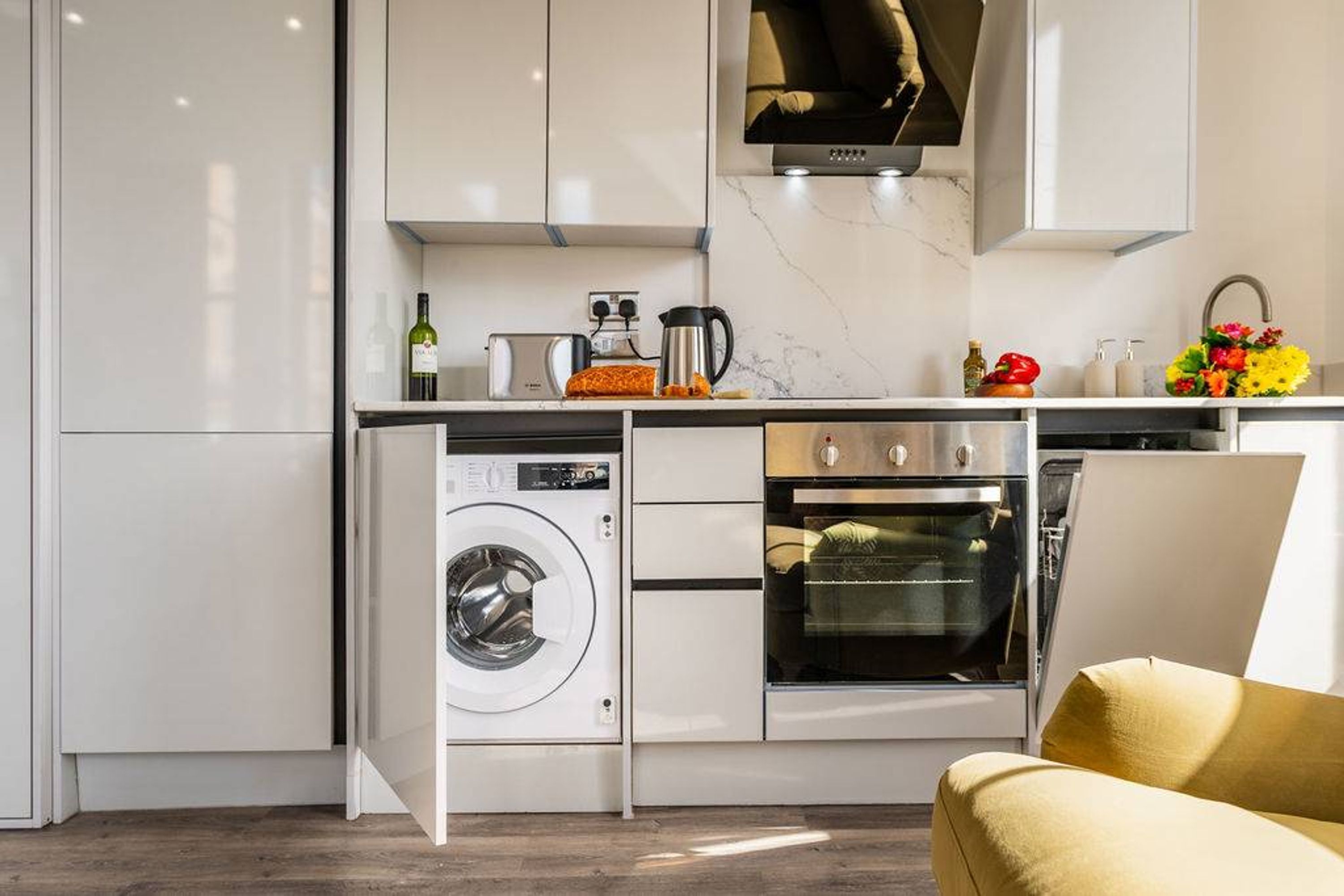 A compact kitchen with a built-in washer, oven, and microwave.