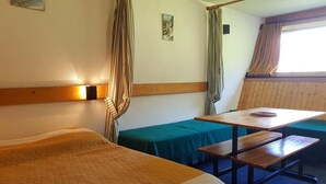 Een hotelkamer met twee bedden, een tafel en een bank.