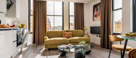 A modern living room with a sofa, coffee table, and dining area.