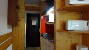 A compact kitchen with wooden cabinets, a microwave, and a coffee maker. - 50m from ski slopes, 1st floor, balcony, tv, 30m², Les Arcs (Les Arcs)