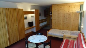 A compact room with a round table, two chairs, a single bed, and a small sofa. - 50m from ski slopes, 1st floor, balcony, tv, 30m², Les Arcs (Les Arcs)