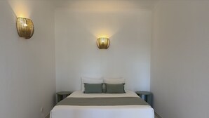 Een slaapkamer met een bed, twee nachtkastjes en twee wandlampen.