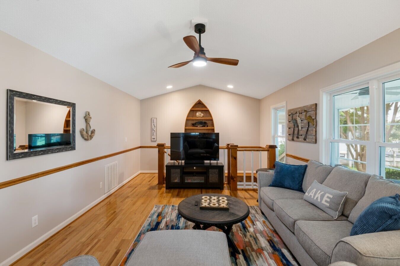 A living room with a TV, sofa, and wooden flooring.