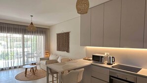 Una cucina moderna con zona pranzo, ampie finestre e angolo cottura.