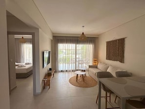 Ein modernes Wohnzimmer mit einer Couch, einem Couchtisch, einem Fernseher und einem Essbereich.