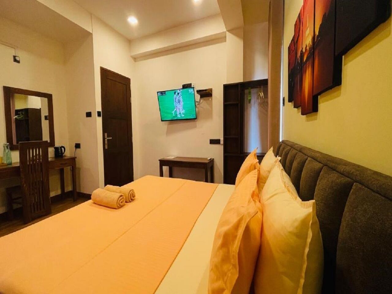 A hotel room with a bed, a television, a desk, and a chair.