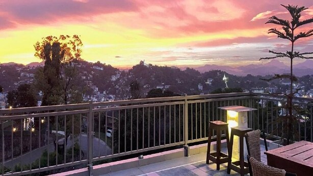 A balcony with a view of a cityscape during sunset. - Sun Dove Suit - Kandy (Kandy)