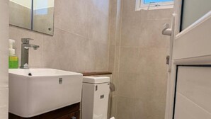 A bathroom with a white sink, a toilet, and a mirror. - Sun Dove Suit - Kandy (Kandy)