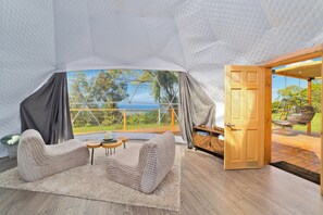 Um quarto aconchegante com uma janela grande, uma porta de madeira e vista para o exterior.