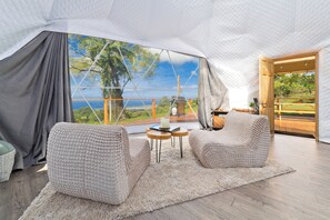 Um interior acolhedor com uma grande janela, soalho de madeira e vista para o verde.