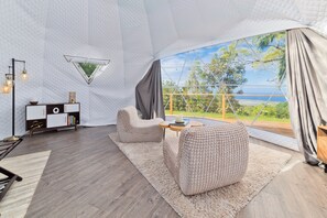 Um interior moderno com uma janela grande, uma mesa redonda e um sofá.