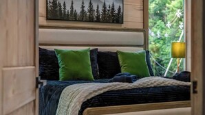 A bedroom with a bed, pillows, a blanket, a painting, and a lamp. - Gatlinburg 3BR | Indoor Pool + Pickleball Court (Gatlinburg)