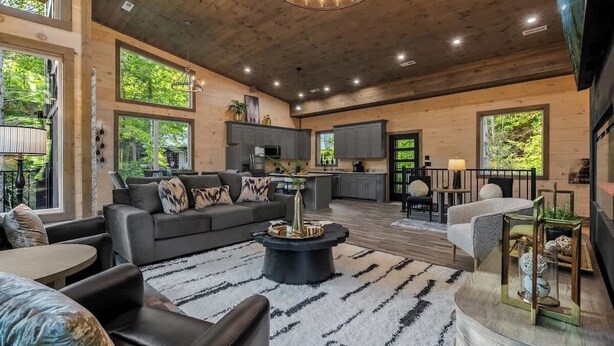 A spacious living area with a large sofa, a coffee table, and a dining area with a table and chairs. - Gatlinburg 3BR | Indoor Pool + Pickleball Court (Gatlinburg)