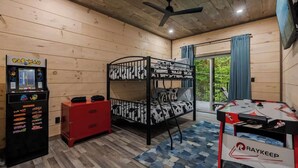 A room with a bunk bed, a foosball table, a vending machine, and a red cabinet. - Gatlinburg 3BR | Indoor Pool + Pickleball Court (Gatlinburg)