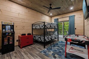 A room with a bunk bed, a foosball table, a vending machine, and a red cabinet. - Gatlinburg 3BR | Indoor Pool + Pickleball Court (Gatlinburg)