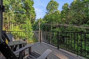 A wooden deck with a metal railing overlooking a forested area. - Gatlinburg 3BR | Indoor Pool + Pickleball Court (Gatlinburg)