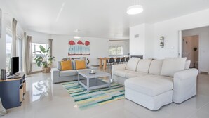 En moderne stue med sofa, sofabord og fjernsyn.